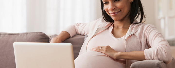 Pregnant mom doing research on laptop